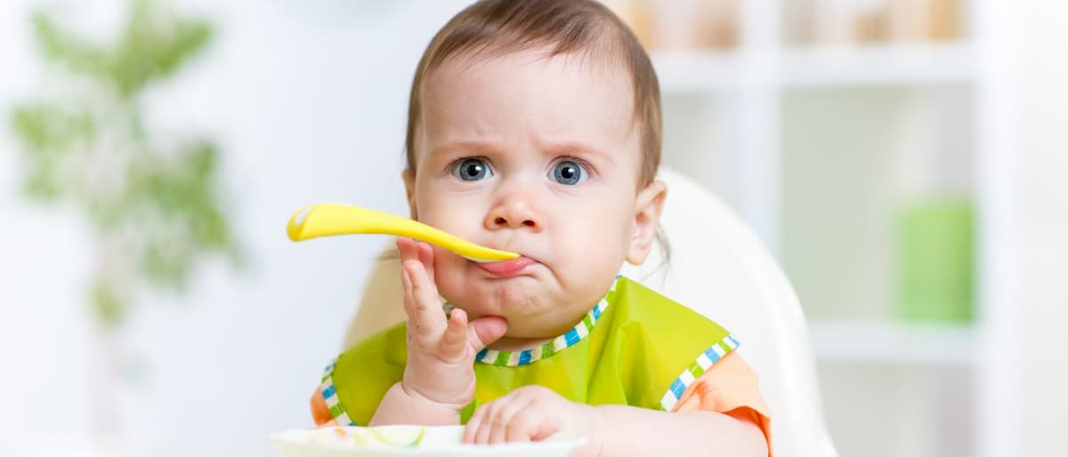 Bambino al seggiolone durante lo svezzamento